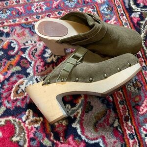 Green suede studded wooden clogs.